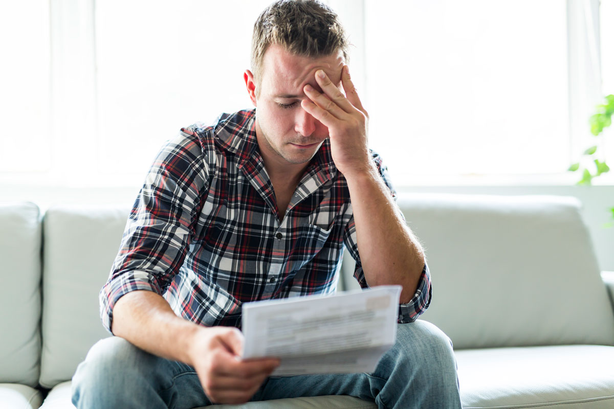 photo of a man reviewing his credit report showing how bad his credit situation is and the challenges he will face when applying for a mortgage