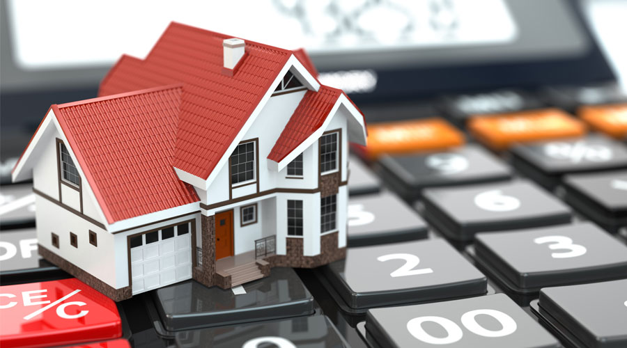 photo of a calculator holding up a house, showing the importance of planning your mortgage financing with a mortgage professional such as Advantage Mortgage